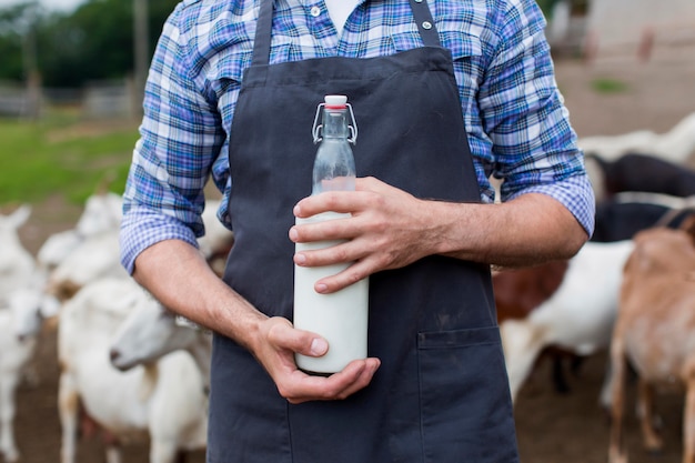 Hombre de primer plano con botella de leche de cabra