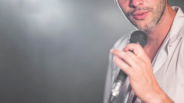 Foto gratuita hombre de primer plano cantando en el micrófono