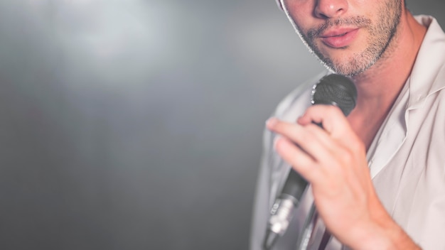 Hombre de primer plano cantando en el micrófono