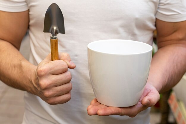 Hombre de primer plano con maceta y herramientas de jardinería