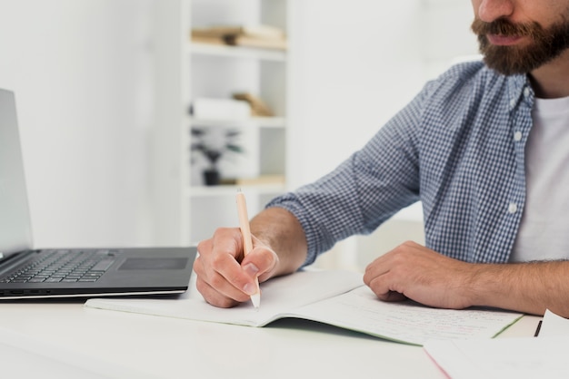 Foto gratuita hombre de primer plano en la oficina escribiendo maqueta