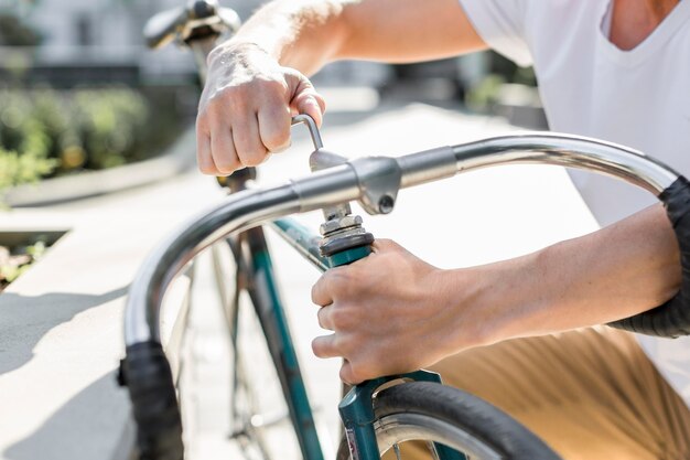 Hombre de primer plano reparando su bicicleta