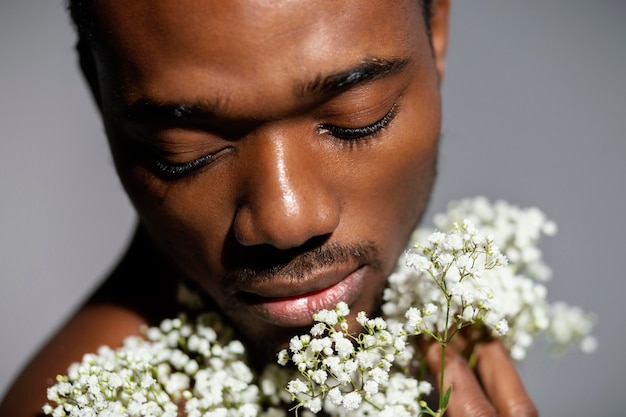 Hombre de primer plano sosteniendo hermosas flores