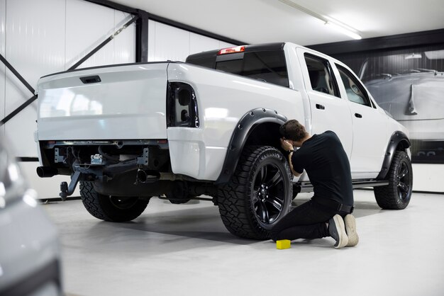 Hombre profesional de tiro completo trabajando en automóvil