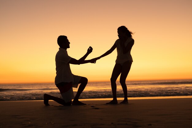 Hombre proponiendo mujer a orilla del mar en la playa