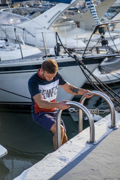 Un hombre en el puerto preparando el yate para el viaje.