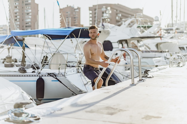 Un hombre en el puerto preparando el yate para el viaje.