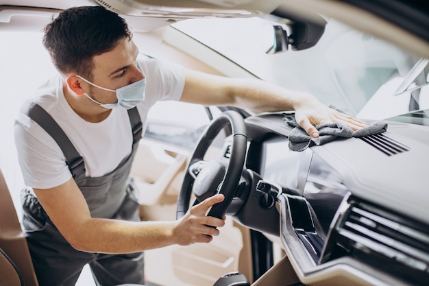 Hombre puliendo el interior del coche en el servicio de coches