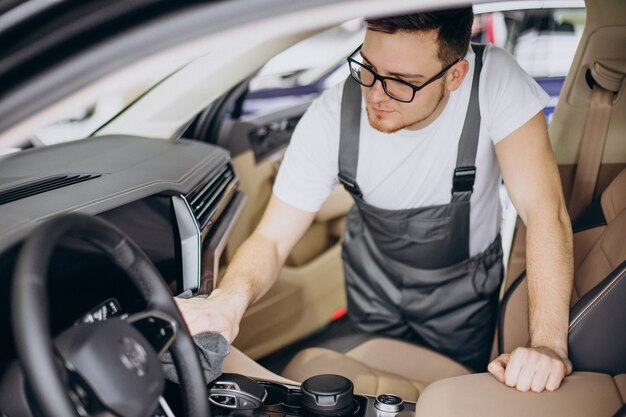 Hombre puliendo el interior del coche en el servicio de coches