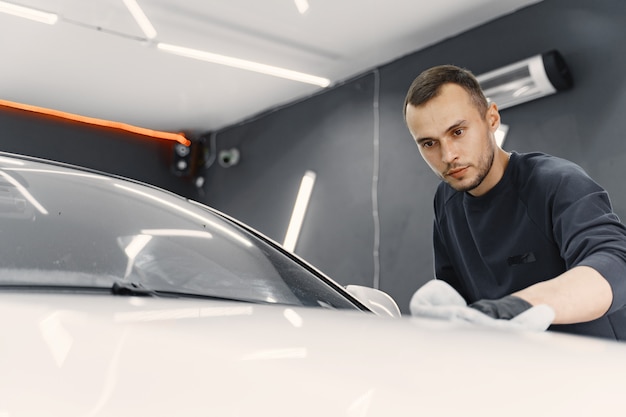 Hombre pulir un auto en un garaje