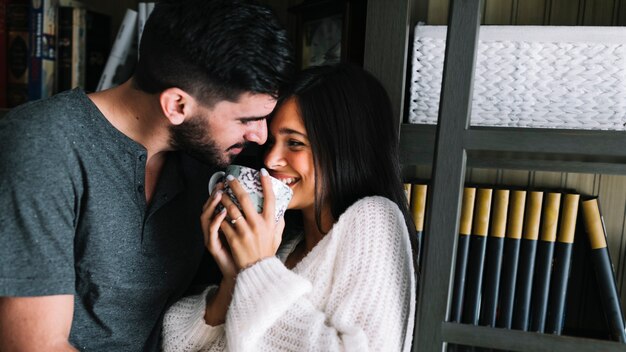 Hombre que ama a su novia que sostiene la taza de café