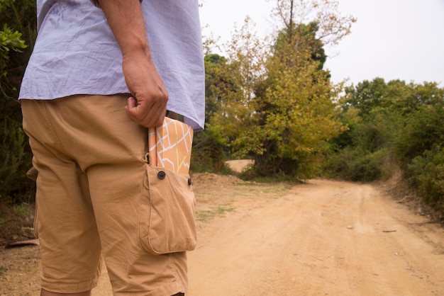 Foto gratuita hombre que se coloca con el mapa del recorrido en bolsillo