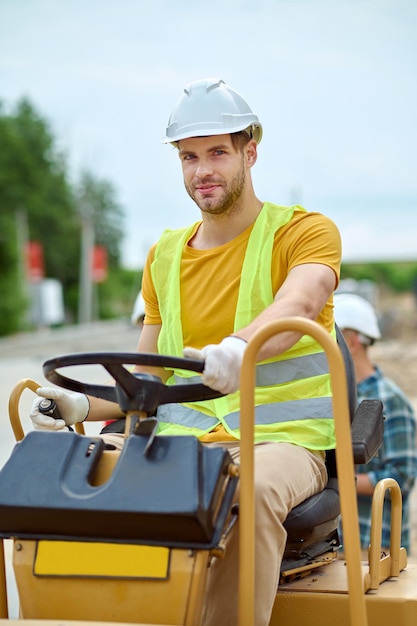 Foto gratuita hombre que conducía un vehículo especial mirando a la cámara