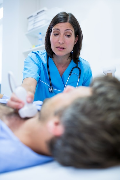 Foto gratuita hombre que consigue ultrasonido de un médico de la tiroides