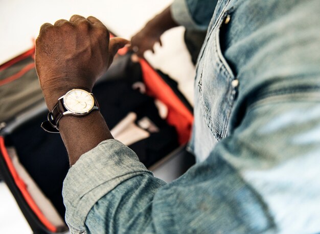 Hombre que controla el tiempo del reloj en la habitación de hotel