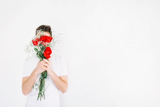 Foto gratuita hombre que cubre la cara con ramo