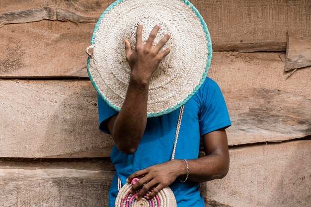 Hombre que cubre la cara con sombrero