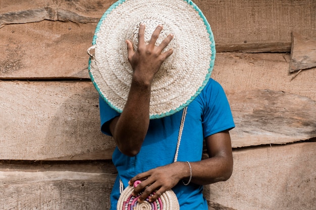 Hombre que cubre la cara con sombrero