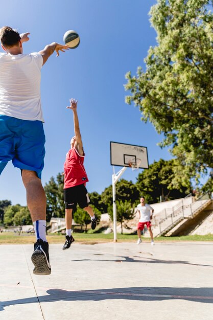 Hombre que defiende el baloncesto lanzado por el otro equipo en el aro