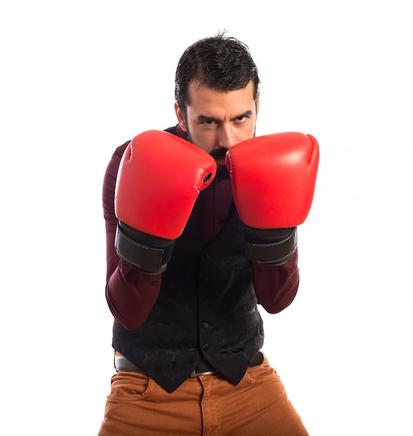 Hombre que desgasta el chaleco con los guantes de boxeo