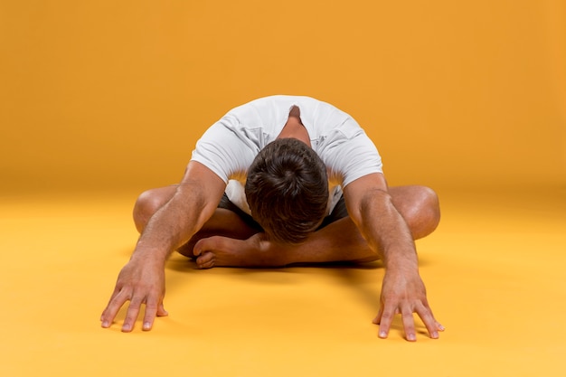 Hombre que se extiende en pose de yoga