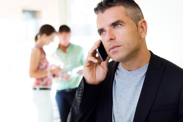 Hombre que invita al teléfono en el fondo borroso