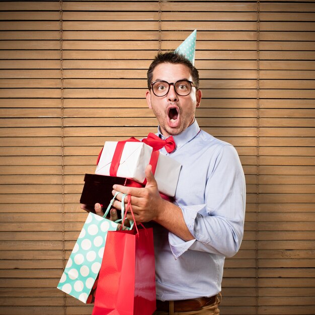 El hombre que lleva una pajarita y sombrero de partido rojo. Celebración de regalo. mirando s