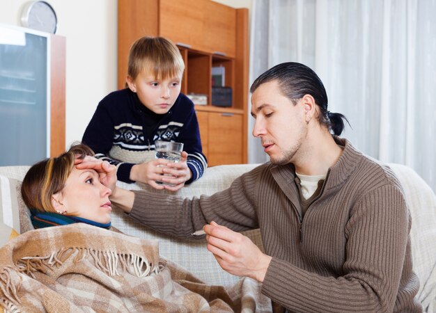 Hombre que mide la temperatura de la esposa enferma