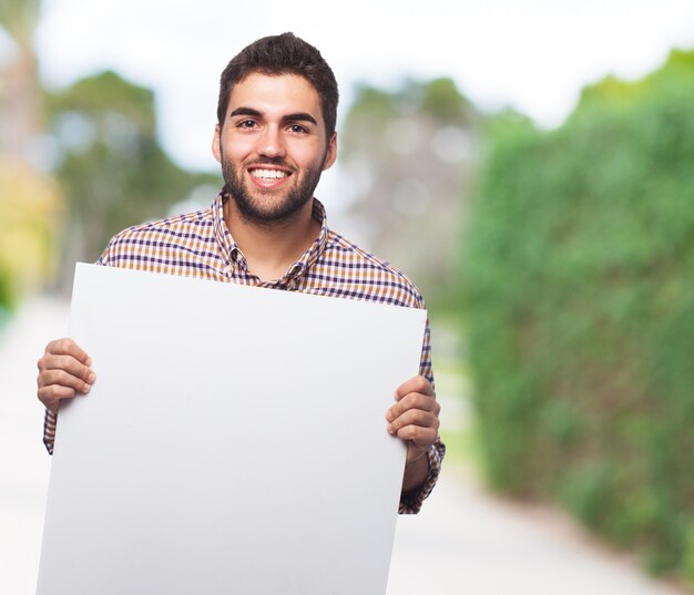 Hombre que muestra una hoja de papel vacía