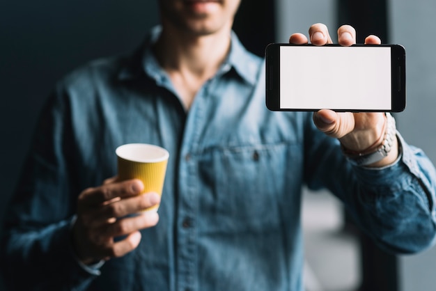 Un hombre que muestra smartphone con pantalla en blanco blanco