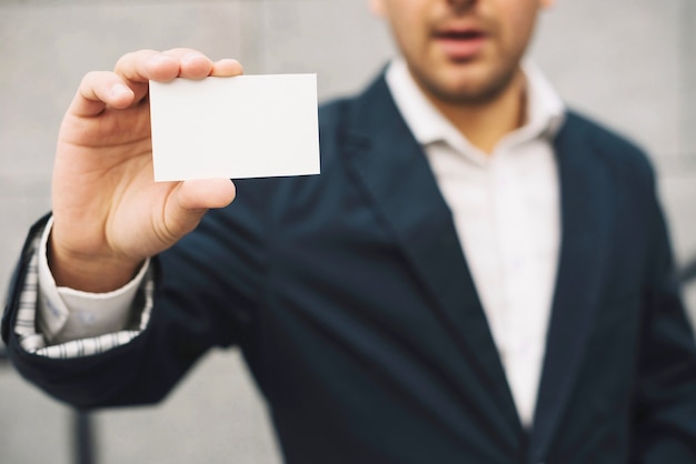 Foto gratuita hombre que muestra la tarjeta de visita en blanco