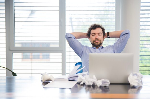 Hombre que se relaja en el lugar de trabajo