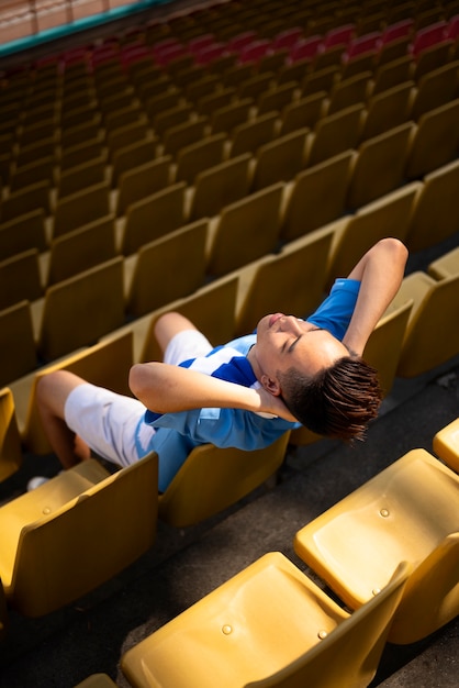 Foto gratuita hombre que sienta, en, tribunas, alto, ángulo