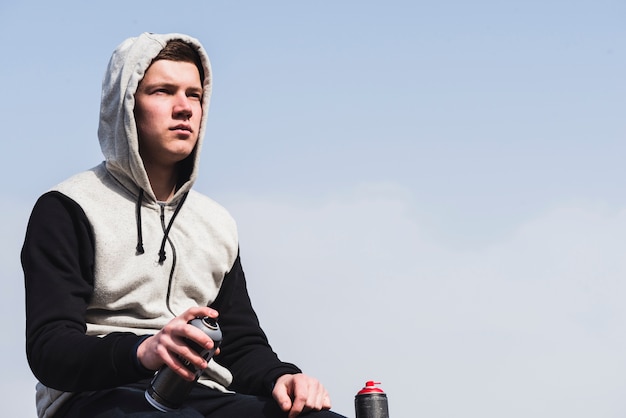 Hombre que sostiene la botella de spray