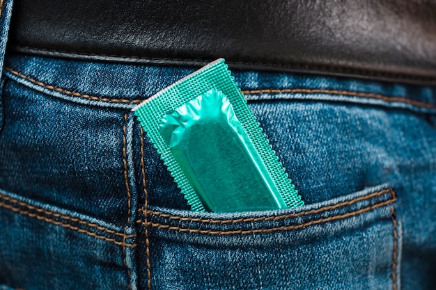 Hombre que sostiene un condón en el bolsillo