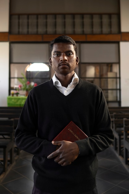 Hombre que sostiene el libro de la biblia en la iglesia