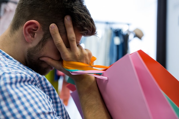 Foto gratuita hombre que sostiene malestar bolsas de la compra