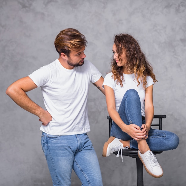 Hombre que sostiene la mano en la cadera y mirando a la mujer