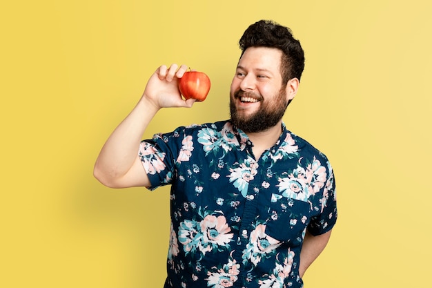 Hombre que sostiene la manzana para la campaña de alimentación saludable