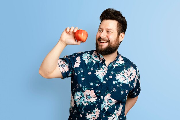 Hombre que sostiene la manzana para la campaña de alimentación saludable