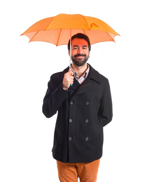 Hombre que sostiene un paraguas sobre el fondo blanco