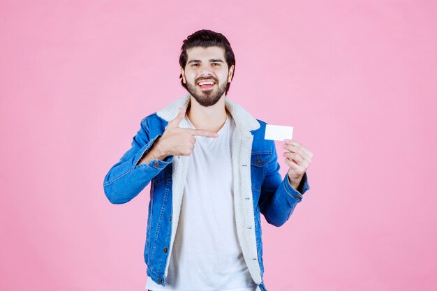 Hombre que sostiene su tarjeta de visita y significa su éxito