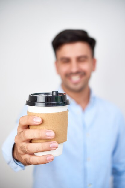 Hombre que sostiene la taza de café de papel