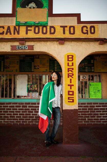 Hombre que sostiene el tiro completo de la bandera mexicana