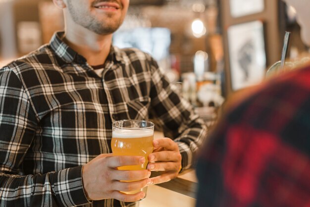 Hombre que sostiene un vaso de cerveza