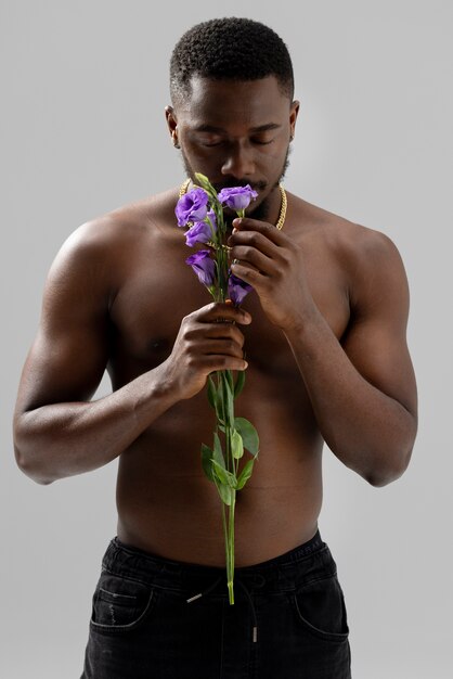 Hombre que sostiene la vista frontal de la flor morada