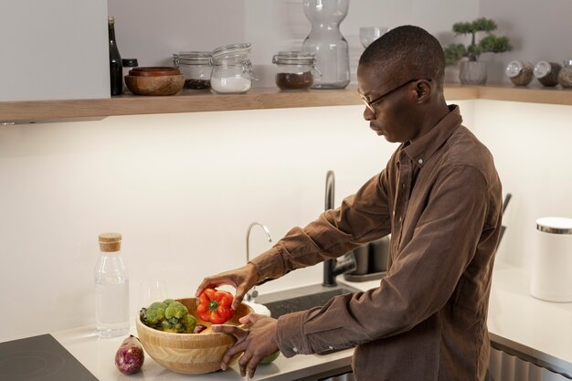 Hombre que sostiene la vista lateral de la cesta de verduras