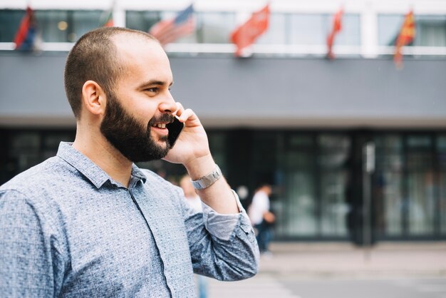 Hombre que tiene conversación telefónica en la calle