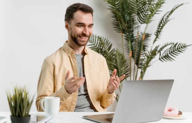 Hombre que tiene videollamada en la computadora portátil