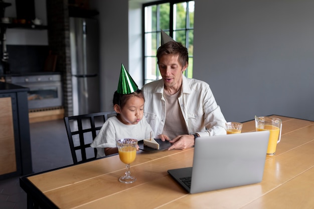 Foto gratuita hombre que tiene una videollamada con su esposa en el cumpleaños de su hija